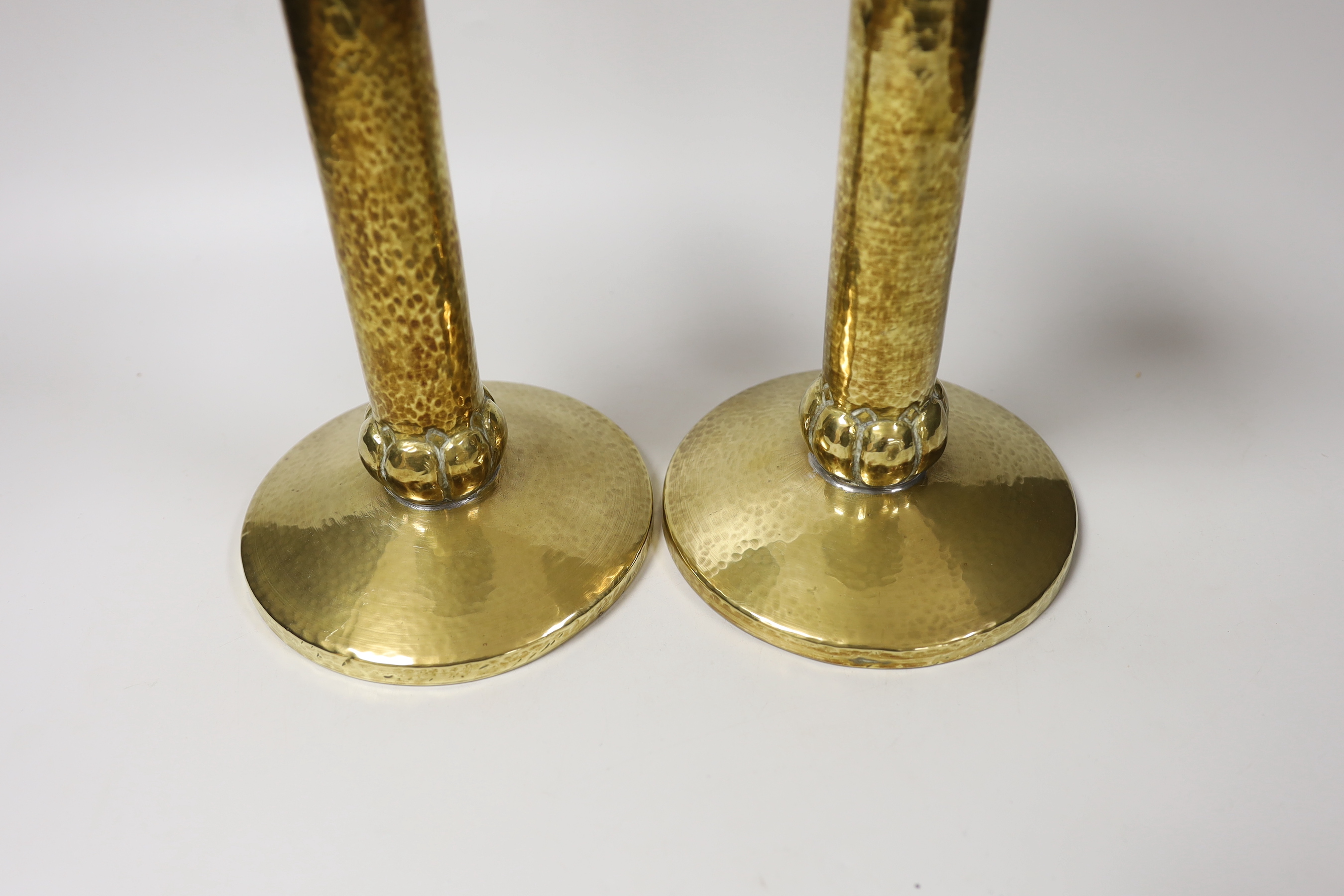 A pair of Arts and Crafts hammered brass candlesticks, with detachable sconces, 21cm